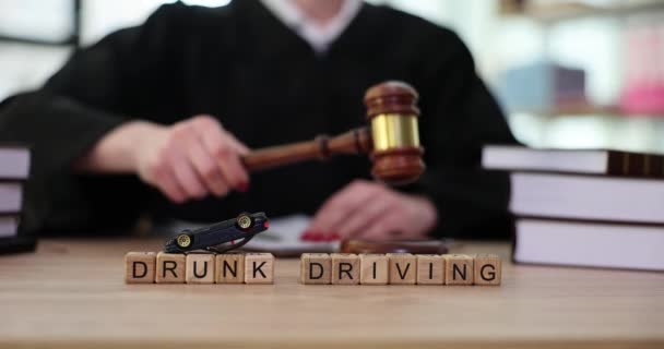 Soudce klepe kladívkem na pozadí slov opilý řízení. Soudní praxe v případě odnětí řidičského průkazu pro řízení pod vlivem alkoholu - Záběry, video