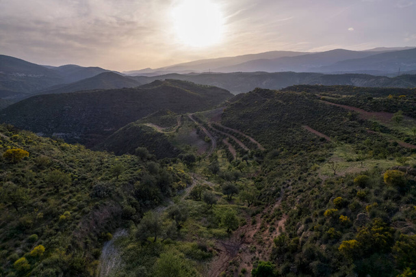 Paisaje montañoso en el sur de Granada (España) hay arbustos y árboles, el cielo tiene nubes - Foto, Imagen
