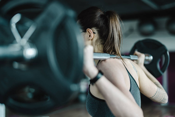 Young woman working out with a barbell at the gym  - Foto, Imagem