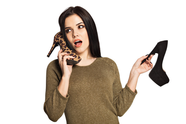 woman holding a shoe next to her ear  pretending to talk - Photo, Image
