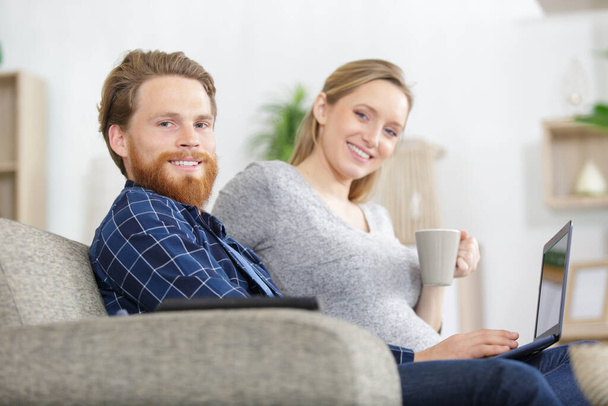 happy lovely couple sits on a sofa at home - Foto, Imagen