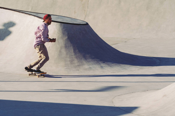 Skateboarder portrait sliding at skate park. Sunset light, life style. - Foto, imagen
