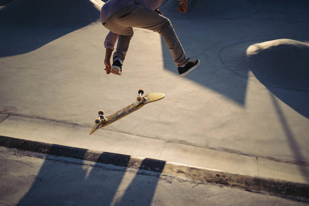 Skateboarder portrait jumping at skate park. Sunset light, life style. - Фото, зображення