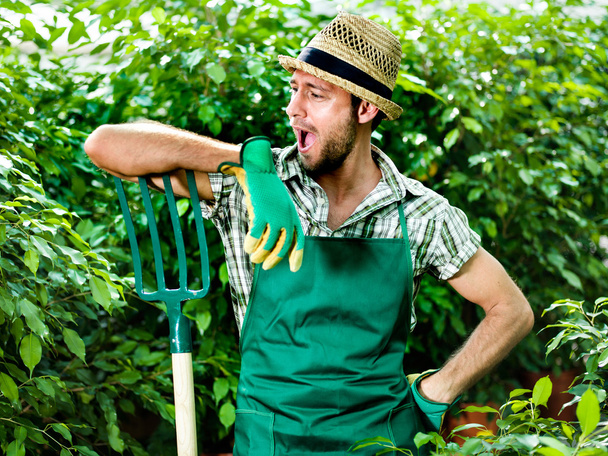 Funny farmer jokes with his pitchfork - Фото, зображення