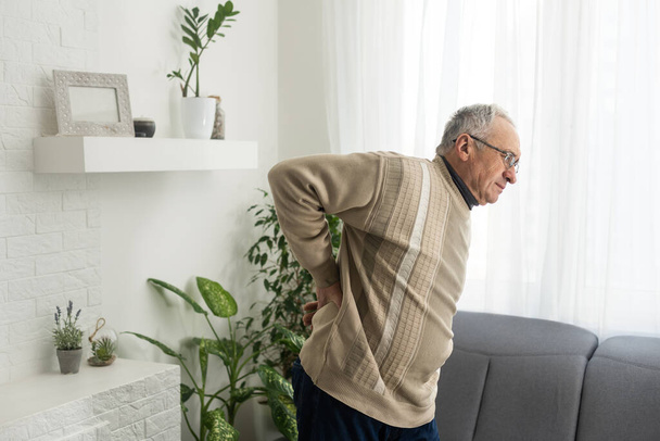 an elderly man has a backache. - Foto, Imagem