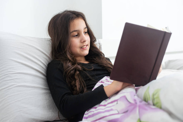 dospívající dívka s knihou v posteli. - Fotografie, Obrázek