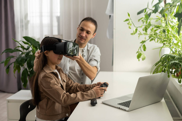 Teenager stands in virtual reality glasses near man. - Foto, afbeelding