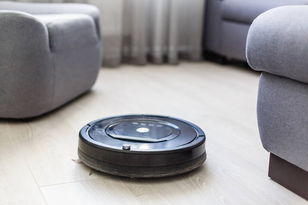 Robot vacuum cleaner, robot vacuum cleaner wipes floors, power button is on and ready to work. - Foto, immagini
