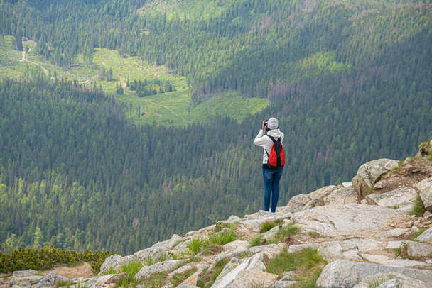 Young woman traveler on a high mountain with a photo camera. - Fotoğraf, Görsel
