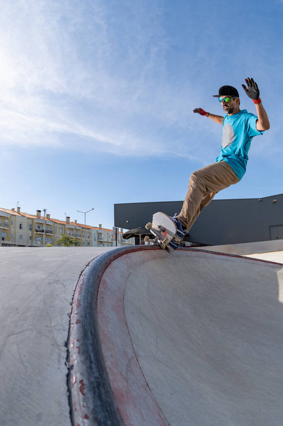 Skateboarder doing frontside five-o grind trick in concrete skatepark. - 写真・画像
