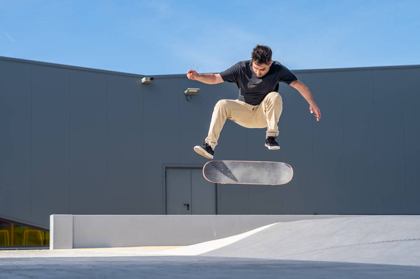Skateboarder doing a flip trick  on a urban scene. - Fotoğraf, Görsel
