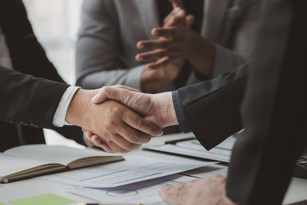 Business investor group holding hands, Two businessmen are agreeing on business together and shaking hands after a successful negotiation. Handshaking is a Western greeting or congratulation. - Foto, Imagem