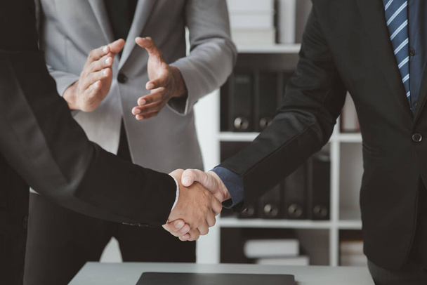 Zakelijke investeerdersgroep hand in hand, twee zakenlieden zijn het eens over zaken samen en schudden elkaar de hand na een succesvolle onderhandeling. Handdrukken is een westerse begroeting of felicitatie. - Foto, afbeelding
