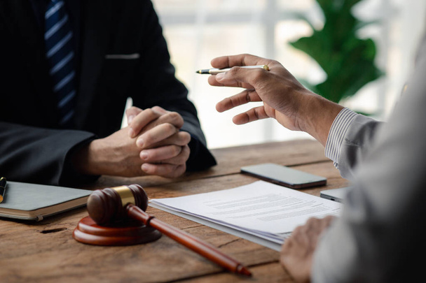 Client was listening to a lawyer advising on an embezzlement case, explaining the details of the proceeding and gathering evidence to file a lawsuit against the defendant. The concept of litigation. - Photo, Image