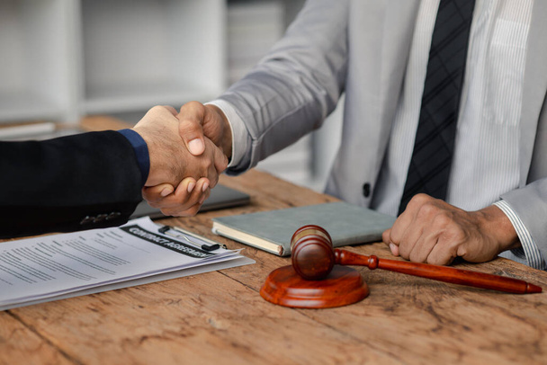 Lawyers shake hands with clients who come to testify in the case of embezzlement from business partners who jointly invest in the business. The concept of hiring a lawyer for legal proceedings. - Foto, imagen