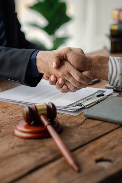 Lawyers shake hands with clients who come to testify in the case of embezzlement from business partners who jointly invest in the business. The concept of hiring a lawyer for legal proceedings. - Foto, Imagen