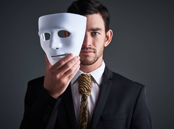 Два обличчя портрет, маска і фальшивий бізнесмен в студії з серйозним обличчям з таємною особистістю. Менеджер і корпоративний чоловік з мотузкою краватка показує корпоративне рабство і контроль в діловому костюмі
. - Фото, зображення
