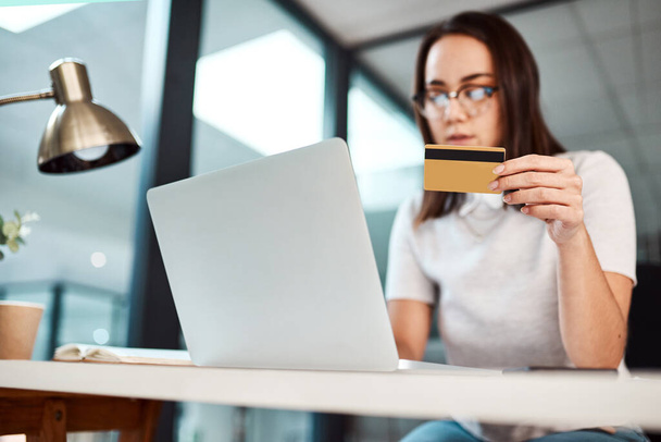 Проведение деловых операций через платформы электронной коммерции. молодая деловая женщина, использующая ноутбук и кредитную карту в офисе - Фото, изображение