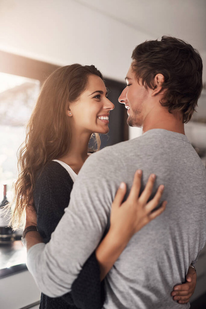 Happy woman, man and hug in apartment for love, care and quality time together with commitment to relationship. Young couple, hugging and smile for anniversary of lovers, relax and loyalty to partner. - Foto, Imagem