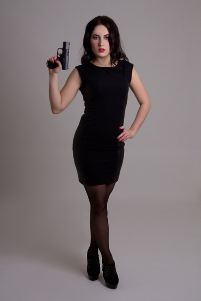 full length portrait of sexy woman in black dress with gun over  - Fotografie, Obrázek