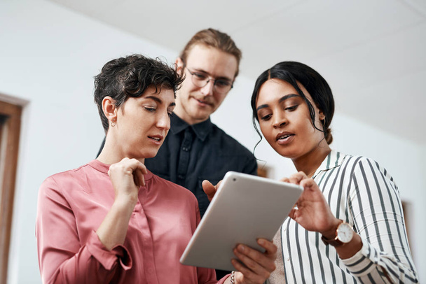 Technologie všechny spojuje. různorodá skupina podnikatelů, kteří stojí při sobě a používají tablet v kanceláři - Fotografie, Obrázek