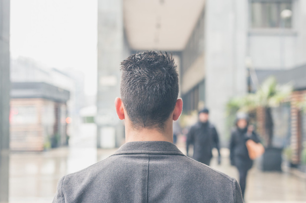 Back view of a young man posing in the city streets - Fotoğraf, Görsel