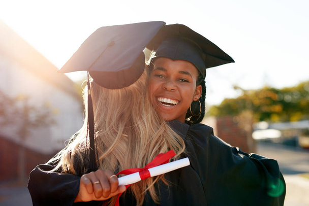 Hug, students and graduation for college or university friends together for congratulations. Portrait of black woman outdoor to celebrate education achievement, success or certificate at school event. - Фото, изображение