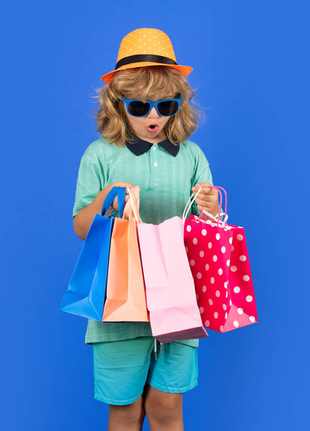 Stüdyoda alışveriş çantalı bir çocuk. Küçük alışveriş çocuğu. - Fotoğraf, Görsel