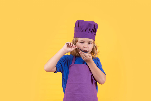 Chef divertido niño cocinero con cuchara, retrato de estudio. Chef niño preparando comida saludable. Retrato de estudio de niño con sombreros de chef - Foto, imagen