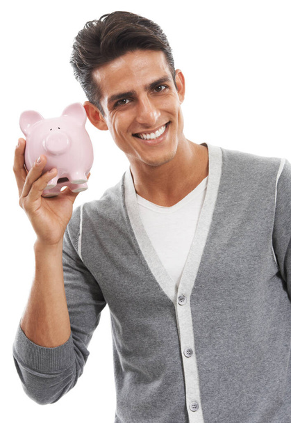Ive got money in the bank. Profile of a handsome young man shaking a piggybank against a white background - Φωτογραφία, εικόνα