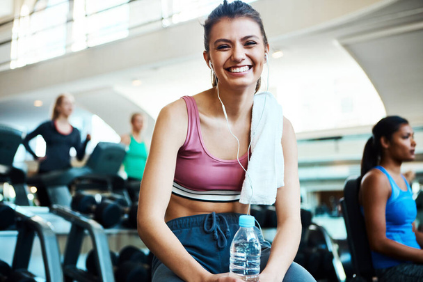 Exercise always makes me happy. Cropped portrait of an attractive young woman taking a break from her workout in the gym - Photo, Image