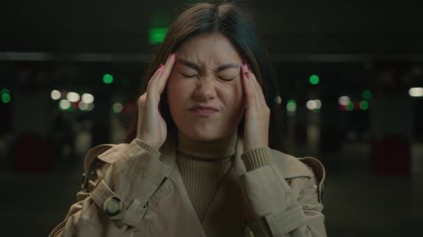 Ázsiai kínai koreai nő egészségtelen lány parkolás japán nő szenved fejfájás migrén fájdalom covid-19 tünet magas vérnyomás üzenet templomok egészségügyi betegség sérülés fájdalmas fejfájás - Felvétel, videó