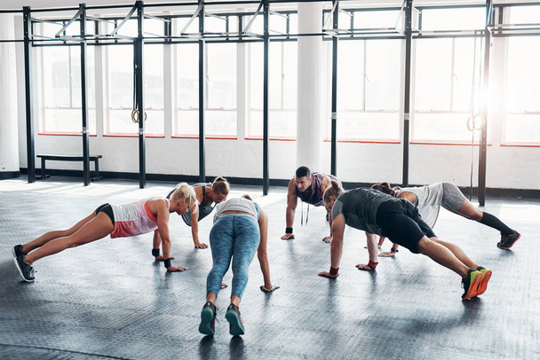 Working out in groups is what motivates us. an accountability working out while forming a circle at the gym - 写真・画像