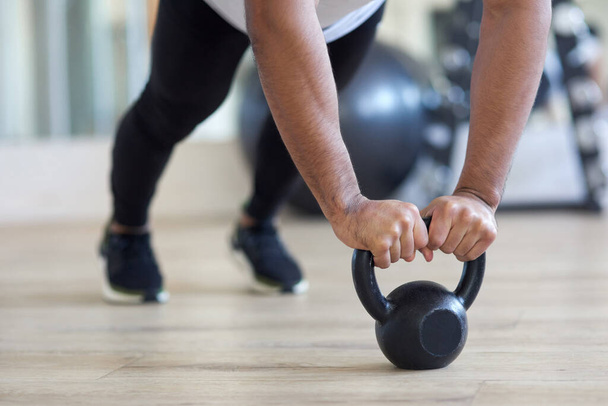 Ignore your excuses and go get it. a male athlete working out with a kettle bell - Foto, Imagen