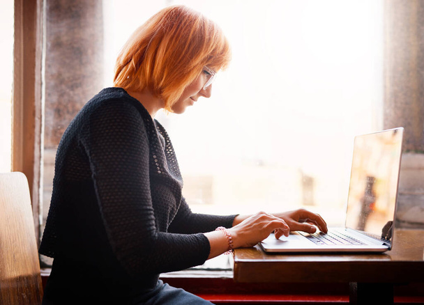 Я всегда выхожу в Интернет. молодая женщина с ноутбуком в кафе - Фото, изображение