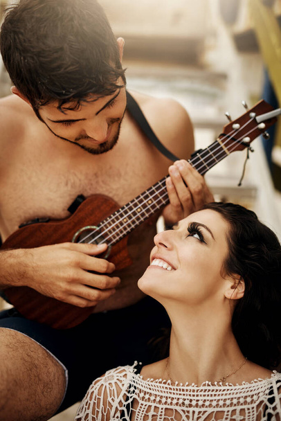 Zbliżamy się do muzyki. młoda para grająca na ukulele na plaży - Zdjęcie, obraz