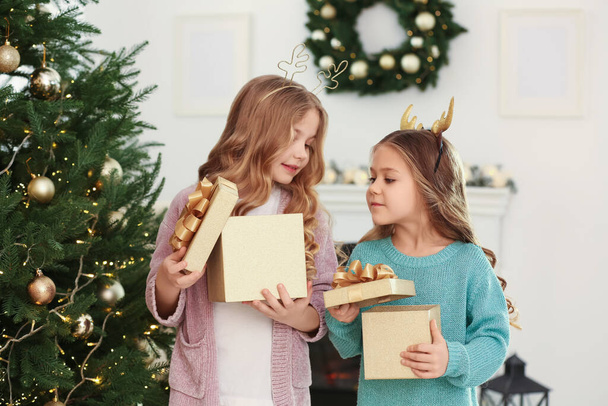 Cute little girls opening Christmas gifts at home - Foto, Imagem