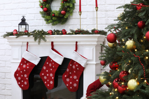 ツリーとクリスマスのために装飾された暖炉付きの居心地の良い部屋。インテリアデザイン - 写真・画像