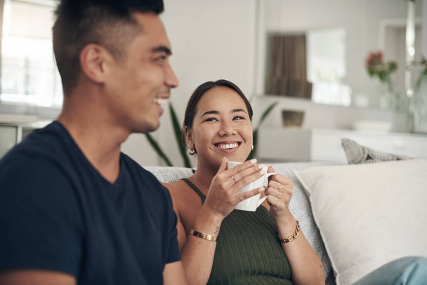 Theres magic between them. a young couple drinking coffee while relaxing together at home - Foto, Bild