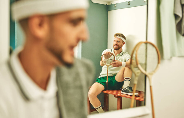 Tons of fun from the court to the locker room. a young man taking a break in the locker room after a game of squash - Foto, imagen