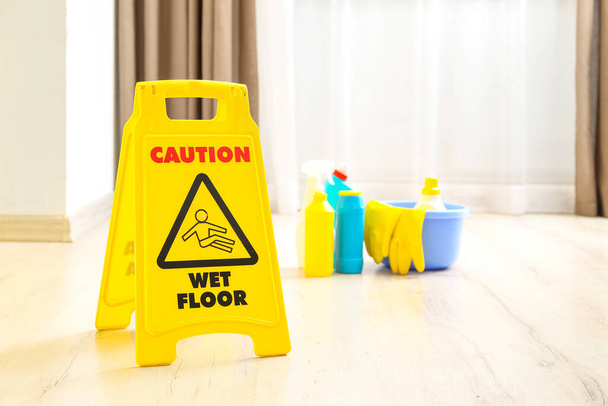 Caution sign on wet floor in room, closeup - Foto, afbeelding