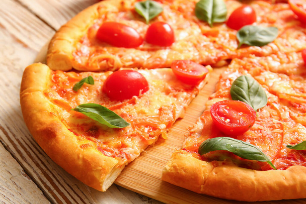 Deska ze smaczną pizzą margarita na białym drewnianym tle - Zdjęcie, obraz