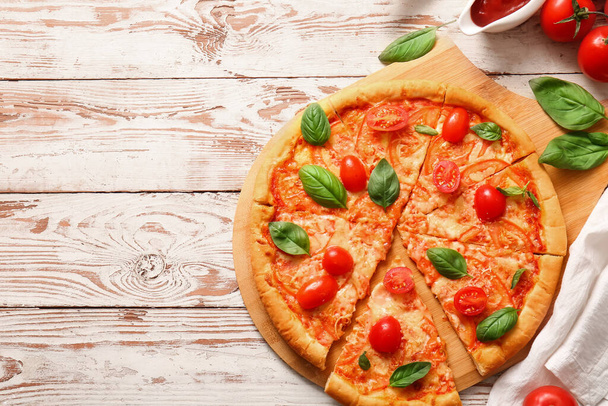 Mesa con sabrosa pizza margarita sobre fondo de madera blanca - Foto, Imagen