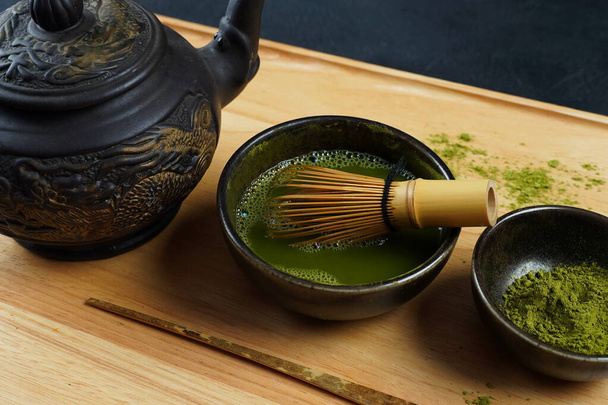 Green matcha tea powder with a bamboo whisk and scoop as used in a traditional Japanese tea ceremony - 写真・画像