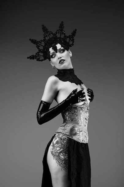 Portrait of a young woman wearing a lace cap, a corset and black latex gloves - Foto, immagini