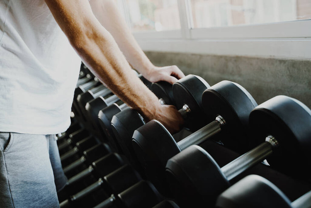 Smart sport man lifting  dumbbell in fitness gym healthy lifestyle - Fotó, kép