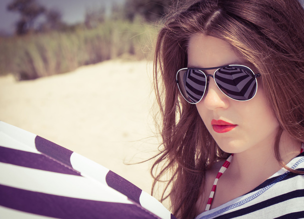 Portrait of a stylish girl in a striped t-shirt and sunglasses b - Photo, Image