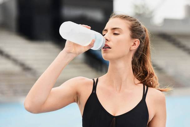 Fitness, woman and runner drinking water for hydration after running exercise, workout or athletic training. Sports, nutrition or thirsty female athlete in rest with drink for natural sustainability. - Zdjęcie, obraz
