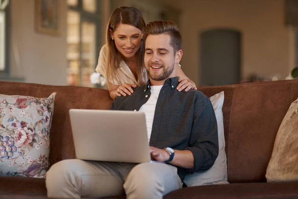 Relax, laptop and web with a couple on the living room sofa of their home together. Computer, social media or internet with a man and woman online to search while relaxing and bonding in a house. - Foto, Imagen