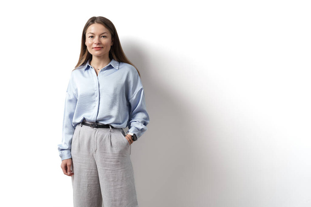Fiatal kaukázusi nő, hivatásos vállalkozó áll irodai ruhák, mosolygós és keres magabiztos fehér háttér - Fotó, kép